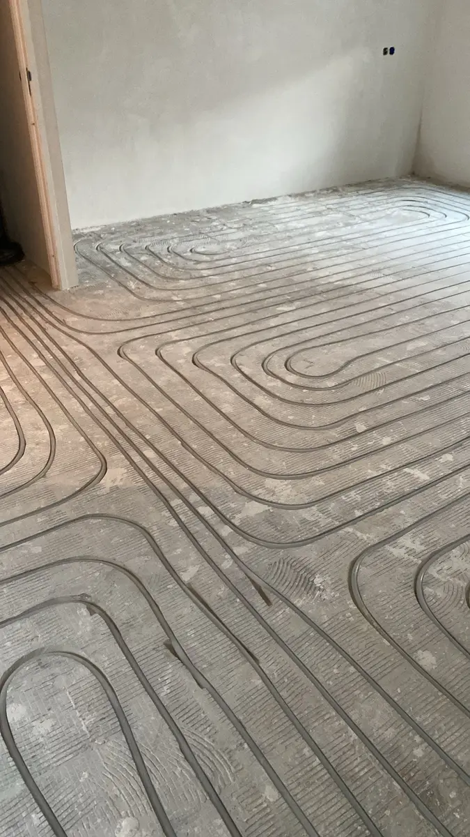 Monteur van Brick by Brick Housing tijdens installatie vloerverwarming